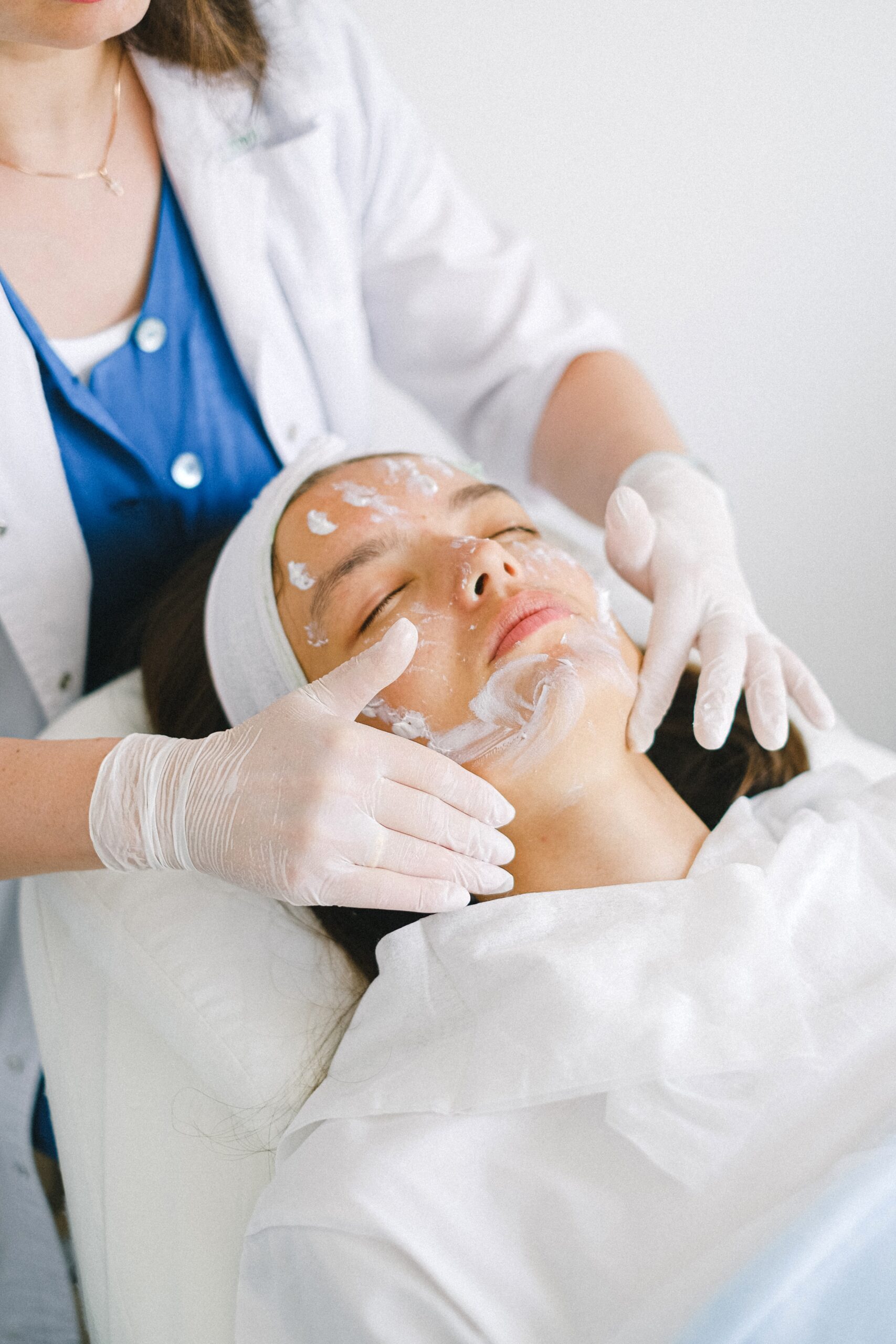 Staff member is applying cream on customer face